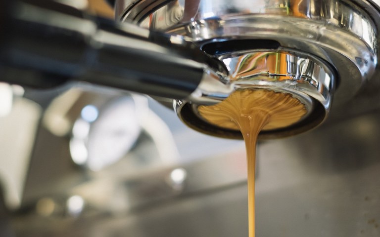 Cremiger Espresso kommt aus der Maschine gelaufen